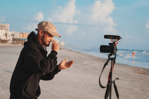 10 Entry-Level Digital Nomad Jobs for Beginners 10 Travel Vlogger making a video on the beach