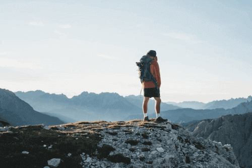 What Size Backpack Do You Need for a Day Hike Man hiking in mountains